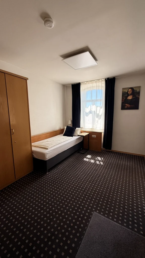 Einzelzimmer im Hotel In Amberg mit Bett und Kleiderschrank